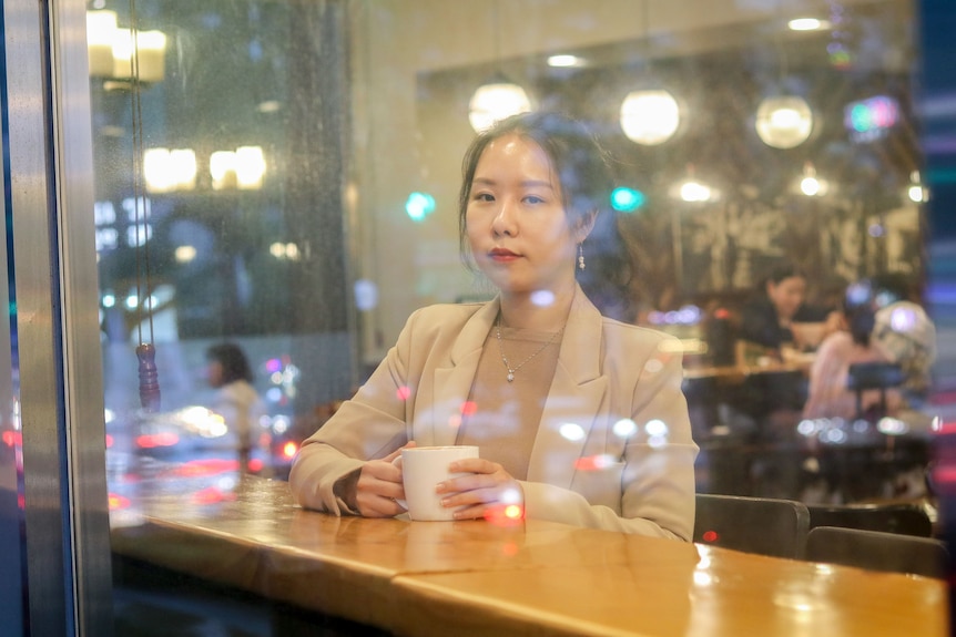 A woman photographed behind a glass window