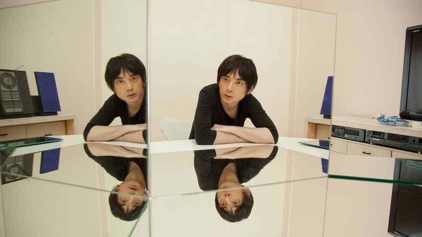 Japanese musician Cornelius looking at his reflection in a series of mirrors