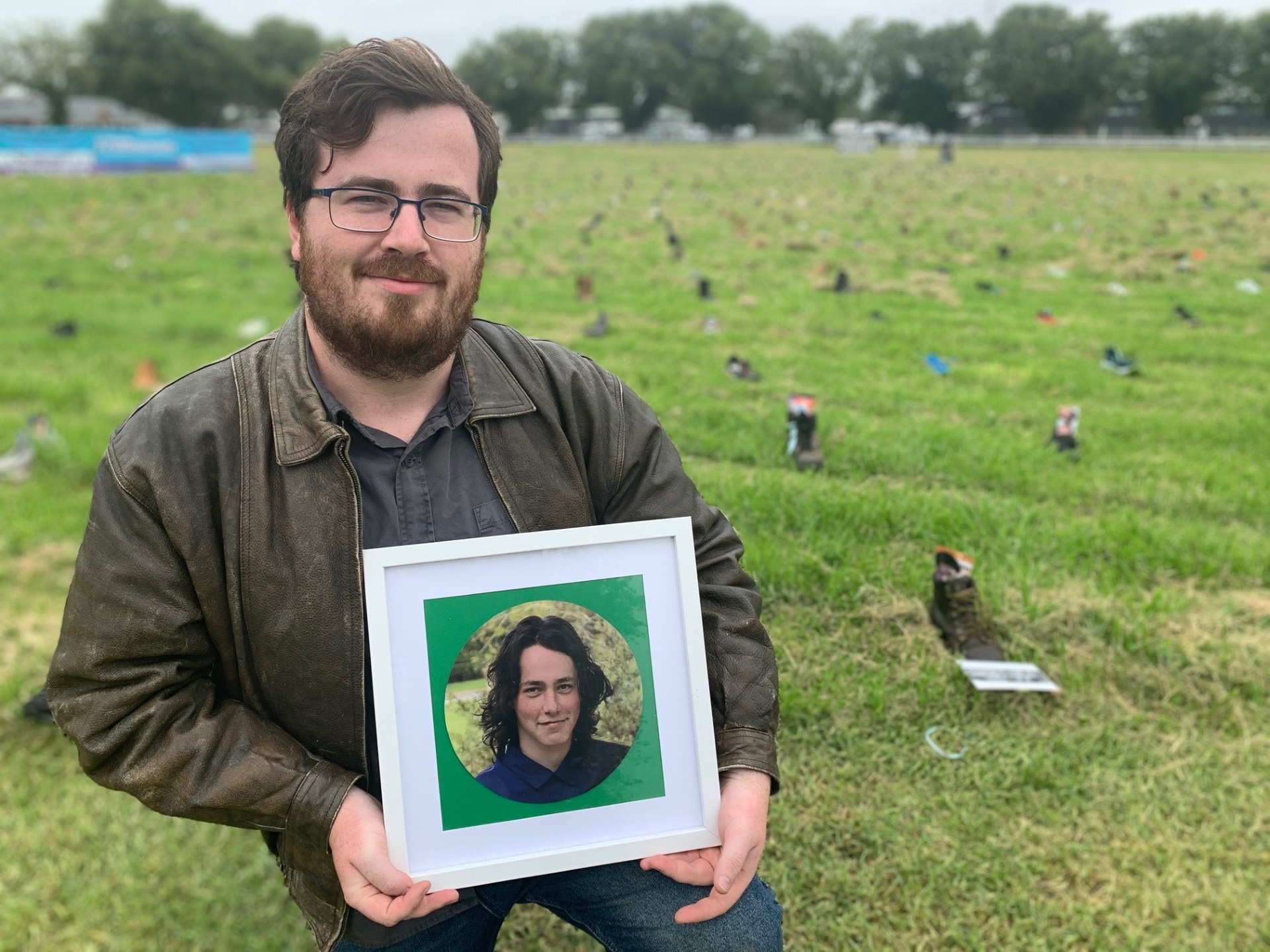 Man holds photo of younger brother.