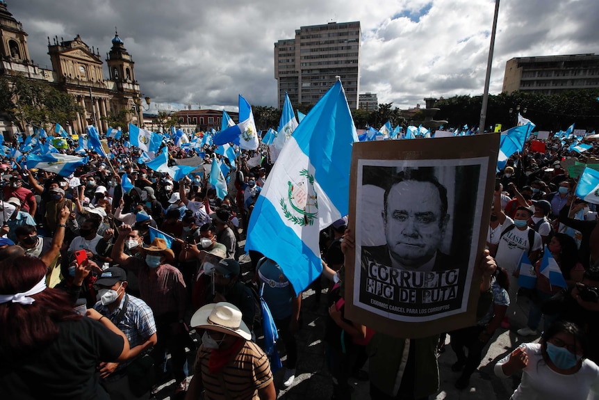 Protesters gather outside Congress in Guatemala City with flags and placards