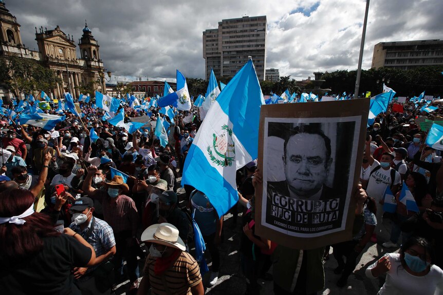 Protesters gather outside Congress in Guatemala City with flags and placards