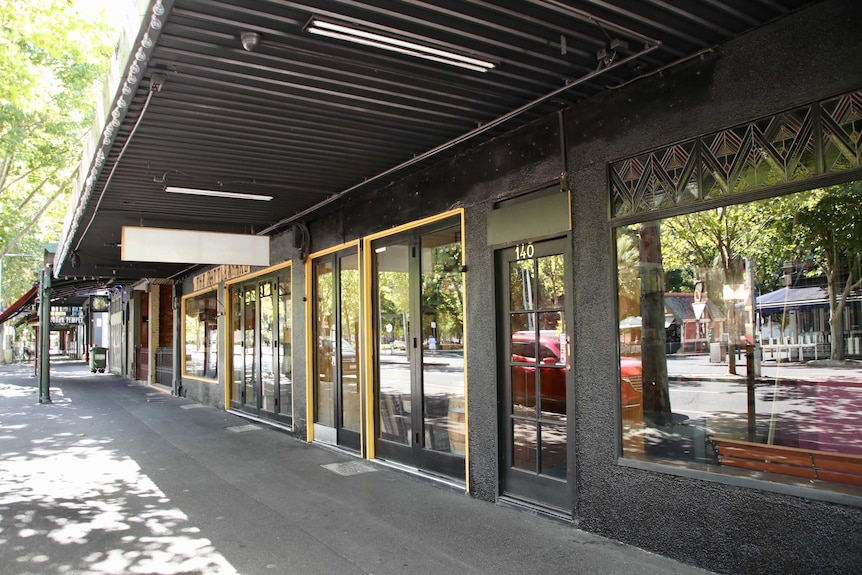 A quiet Lygon St with no pedestrians in sight outside shops.