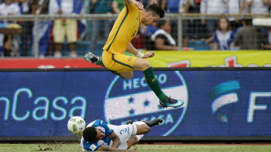 Australia's Tomi Juric jumps over Honduras' Henry Figueroa in the World Cup play-off in Honduras.