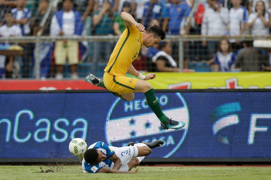 Australia's Tomi Juric jumps over Honduras' Henry Figueroa in the World Cup play-off in Honduras.