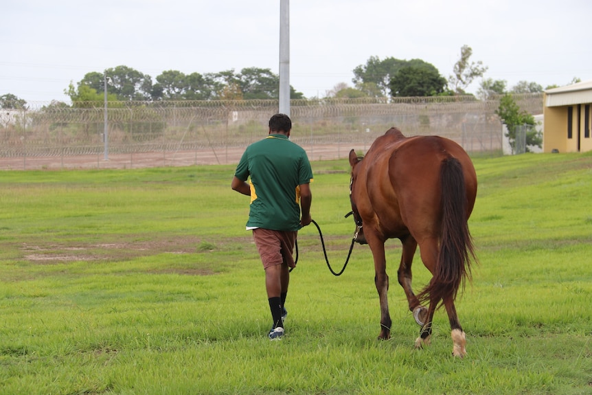 A student leads their horse to be washed after being ridden at Don Dale.