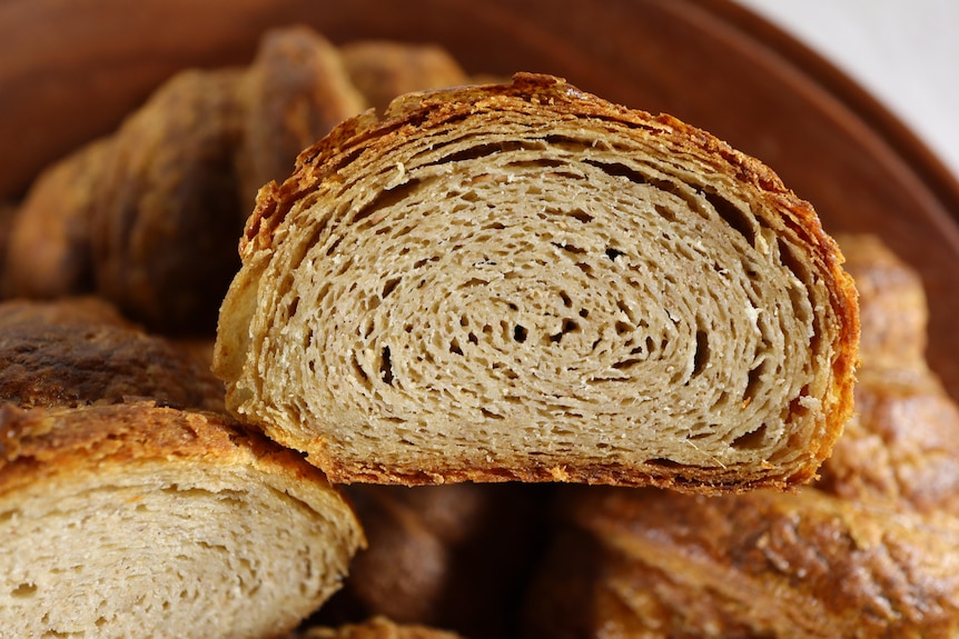 Display shot of croissants cut in half to reveal the soft bread inside.