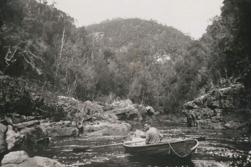 Historic image showingone of the morrison brothers rowing through a narrow Franklin River gorge in the 1940s.