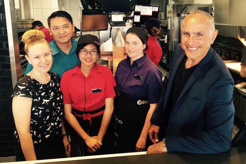 Owner of Mirrabooka McDonalds Ayman Haydar stands in the kitchen with four staff members.