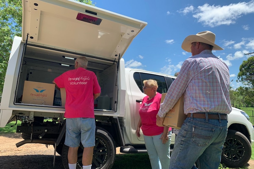 Drought Angels volunteers unload boxes from a van.