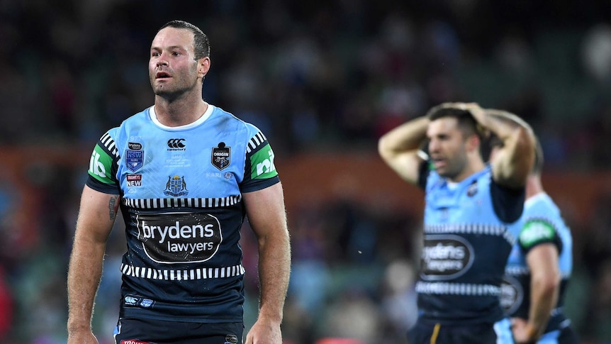 Boyd Cordner walks off as his Blues teammates look on following a loss in State of Origin