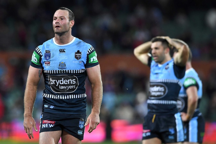 Boyd Cordner walks off as his Blues teammates look on following a loss in State of Origin