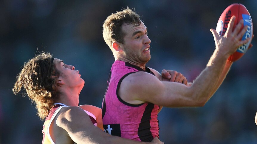 Jarrod Berry tackles Tom Mitchell in the air during the Hawthorn versus Brisbane AFL match.