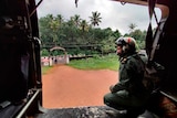 A navy official looks from their helicopter at a flooded village in Kottayam district, Kerala.