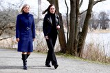 Magdalena Andersson dressed in a blue coat walks with Sanna Marin in a leather jacket.