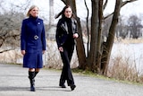 Magdalena Andersson dressed in a blue coat walks with Sanna Marin in a leather jacket.