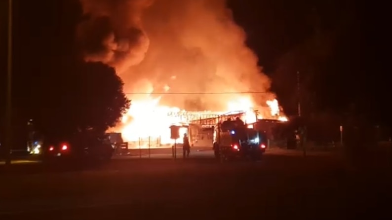 The Nangwarry Football Club is completely engulfed by flames sending clouds of smoke into the air.