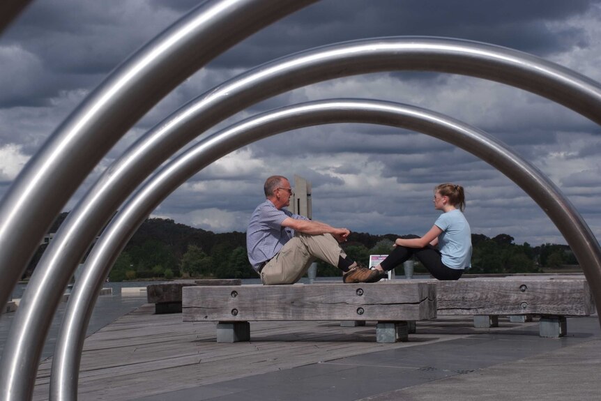 Sarah and Scott Huxtable sit by Lake Burley Griffin.