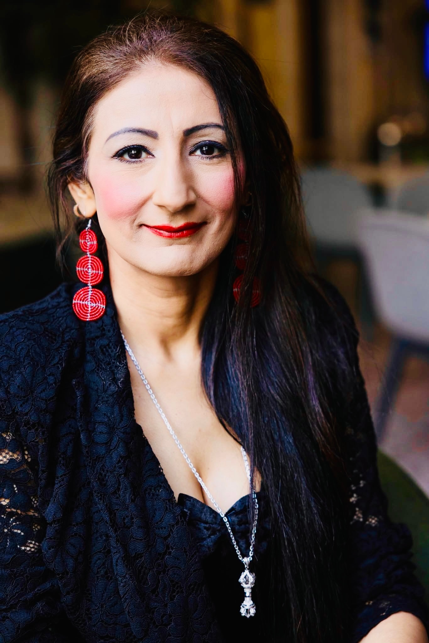 A woman with long black hair looks at the camera.