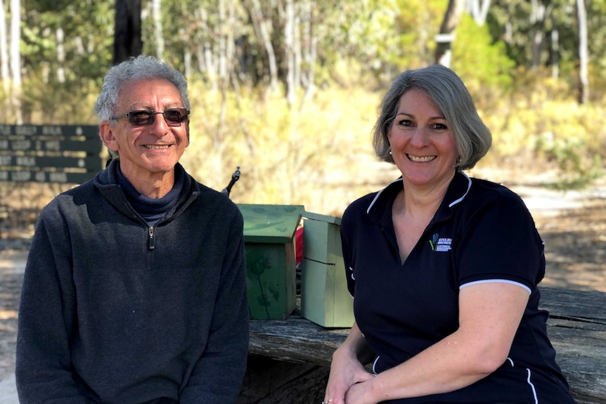 Janice and Orlando sit on a bench in the National Park