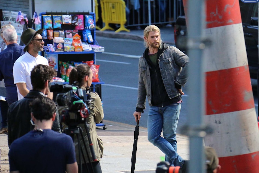 Chris Hemsworth leans on an umbrella on the set of Thor in Brisbane.