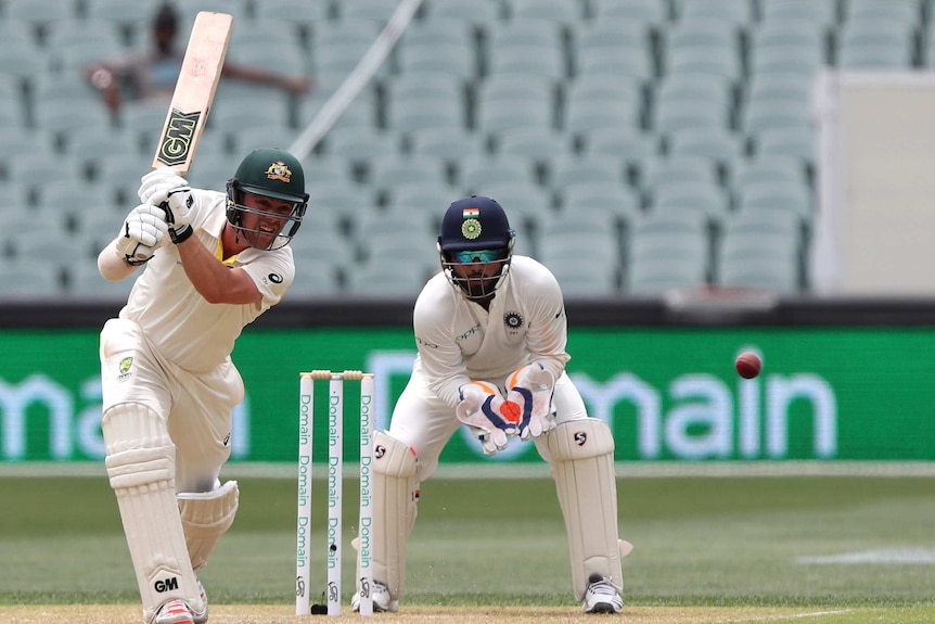 Australia batsman Travis Head drives in front of India wicketkeeper Rishabh Pant.