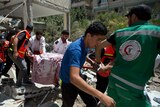 Palestinian medics carry body of woman through rubble in Gaza