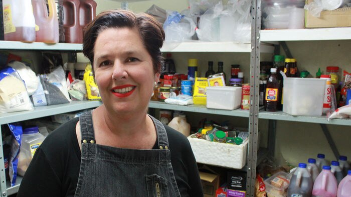 Amanda Hinds in the pantry of her cafe, wearing an apron.