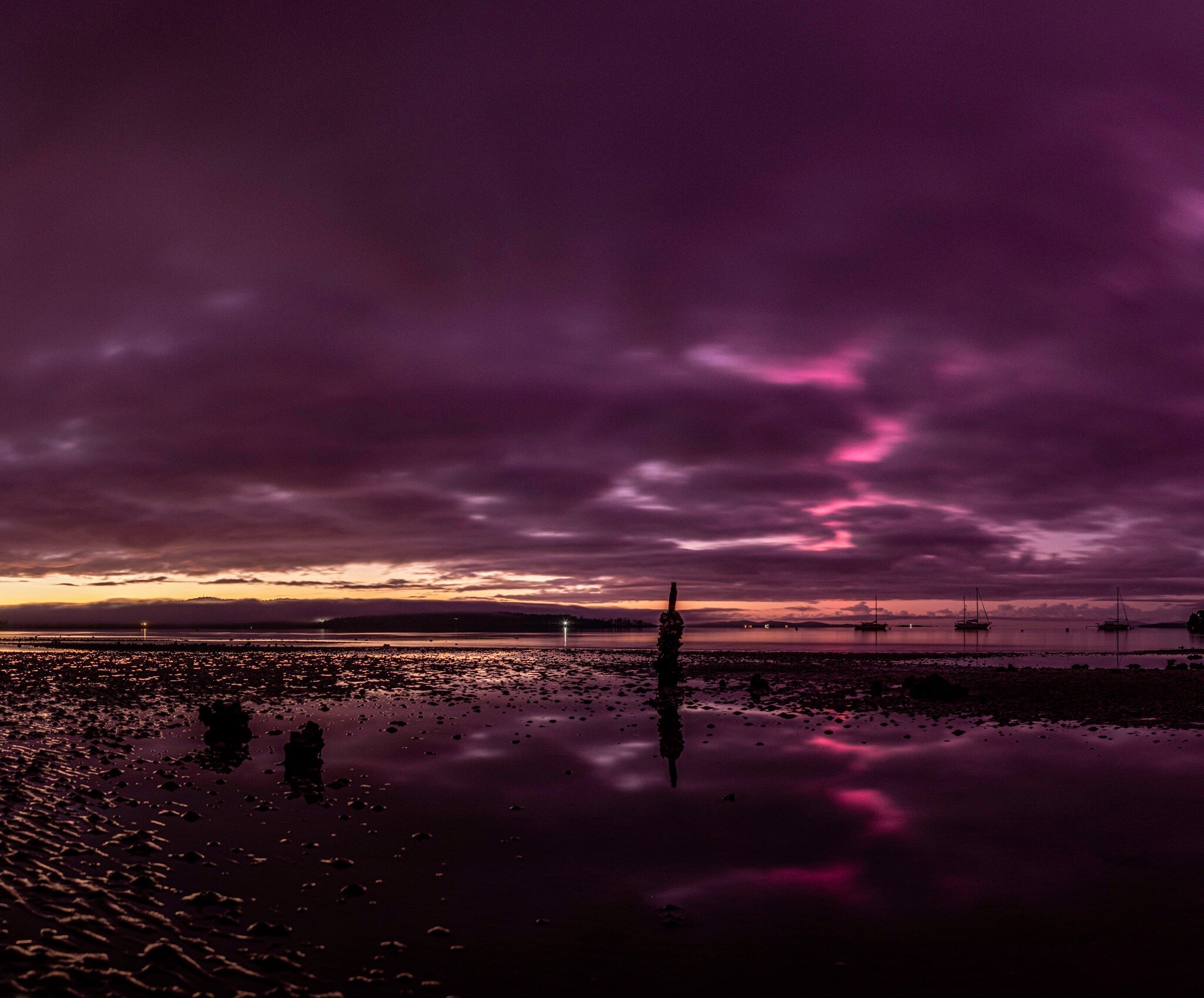 Purple and orange lights in the sky over a beach