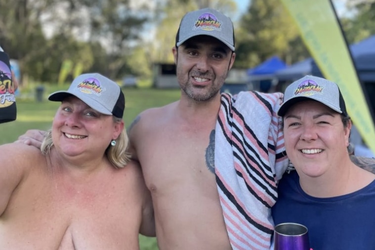 Two women and a man pose for a photograph at the Nude Up Festival