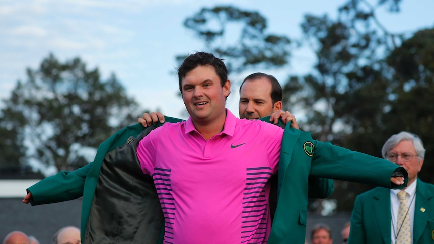 2018 Masters winner Patrick Reed puts on his winners green jacket