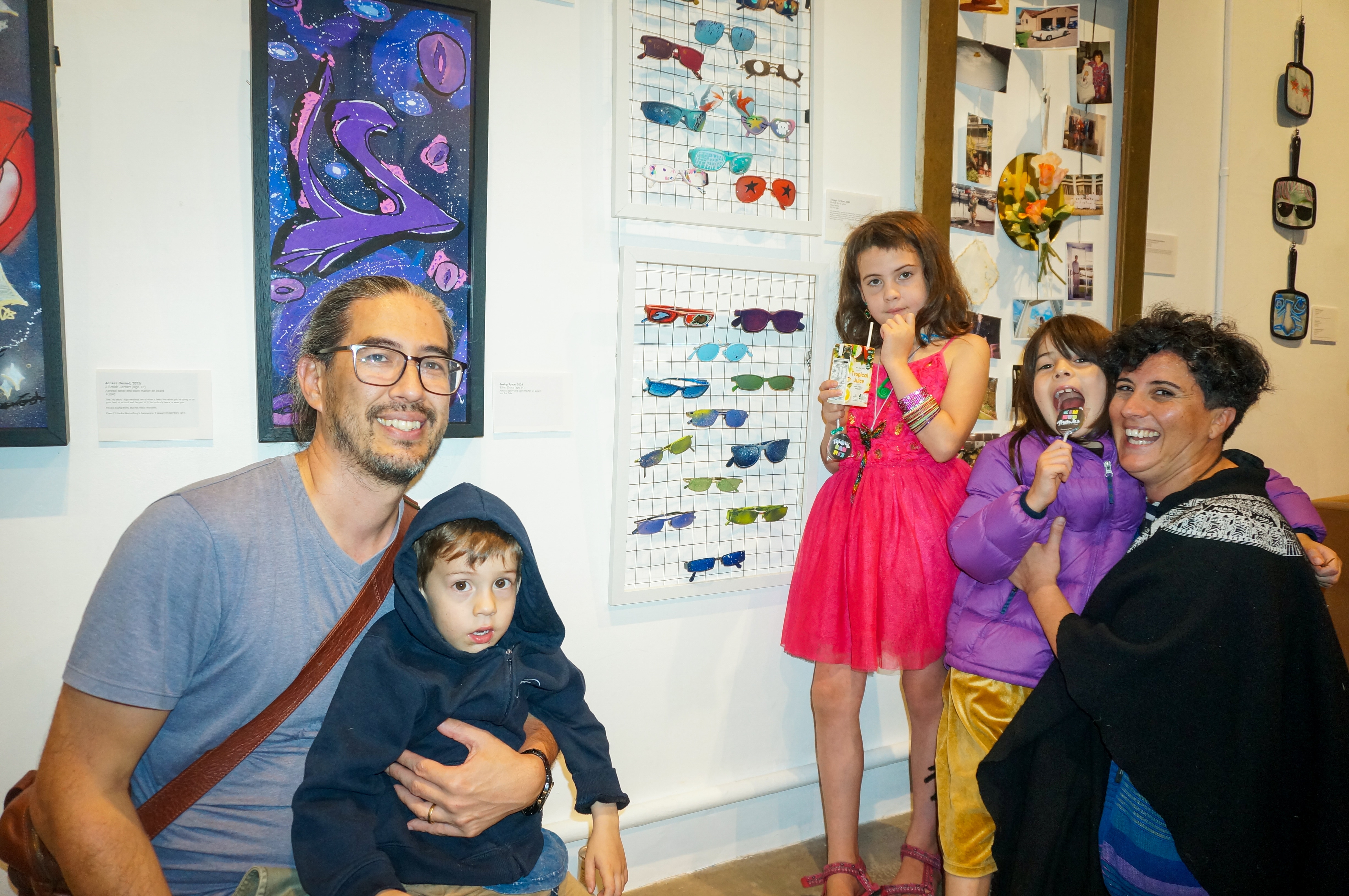 Улыбающаяся семья из пяти человек на выставке в художественной галерее. 