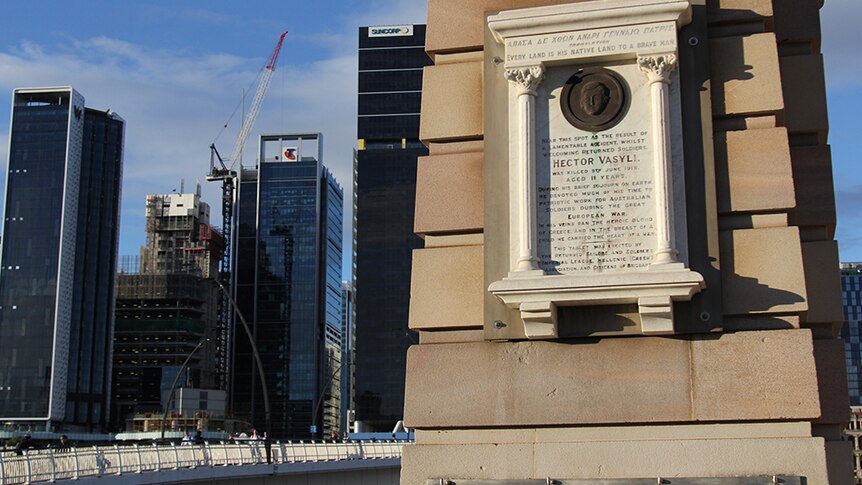 A stone memorial on an archway with Brisbane's Victoria Bridge in the background.