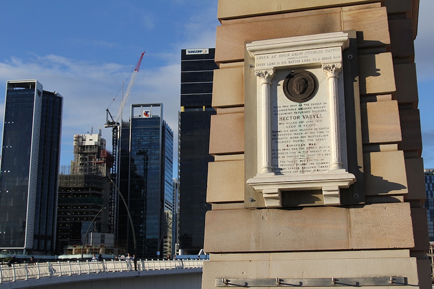 A stone memorial on an archway with Brisbane's Victoria Bridge in the background.