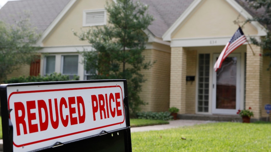 A house in Texas for sale in September 2009, with a reduced price sticker on the sign.