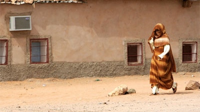 A refugee from Western Sahara passes Polisario President Abdelaziz Mohamed's residence in the '27 February Refugee Camp' in T...