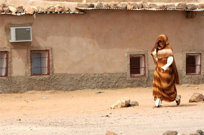 A refugee from Western Sahara passes Polisario President Abdelaziz Mohamed's residence in the '27 February Refugee Camp' in T...