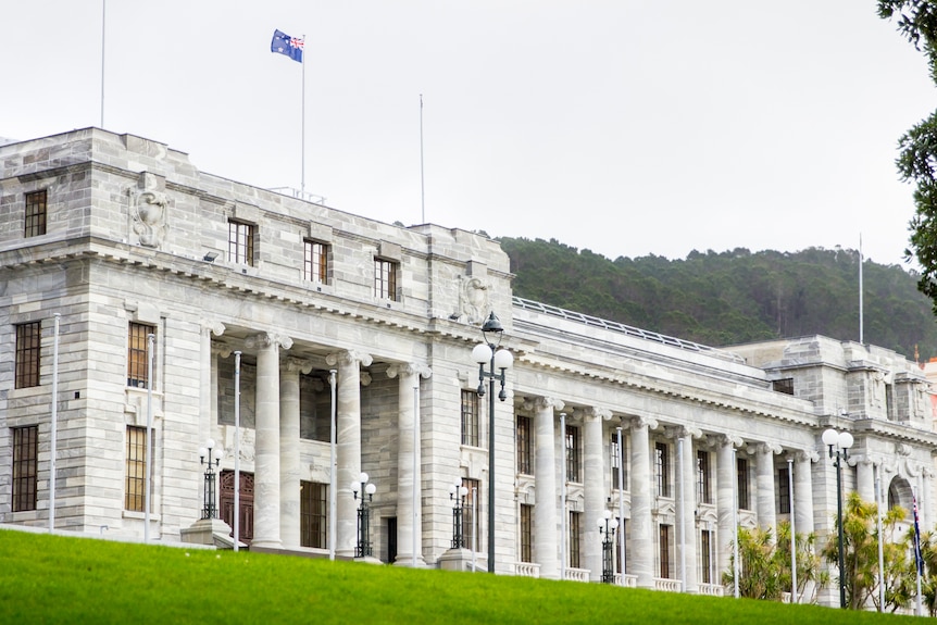 Large stone government building on a green hill