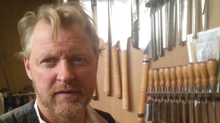 Profile shot of Christian Wolter in a carpeting workshop.