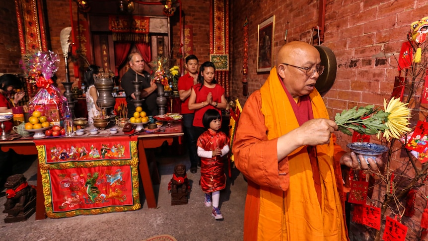 Visiting Vietnamese abbot Thich Giac Minh leading a Melbourne family throughout the Joss House rooms.