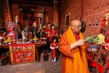 Visiting Vietnamese abbot Thich Giac Minh leading a Melbourne family throughout the Joss House rooms.