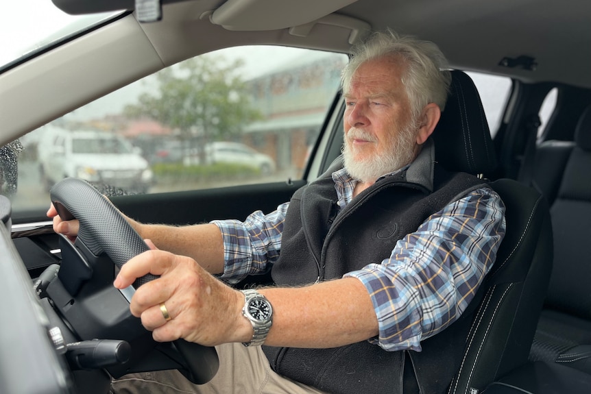 elderly man driving a car