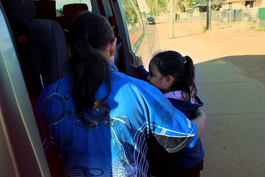 Jenny Craigie helps a Mount Isa student onto the bus.