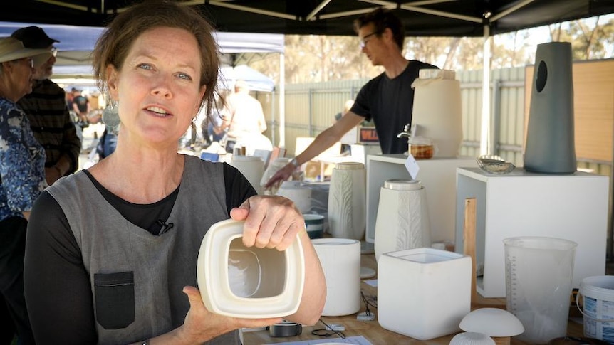Woman holds ceramic fermentation jar