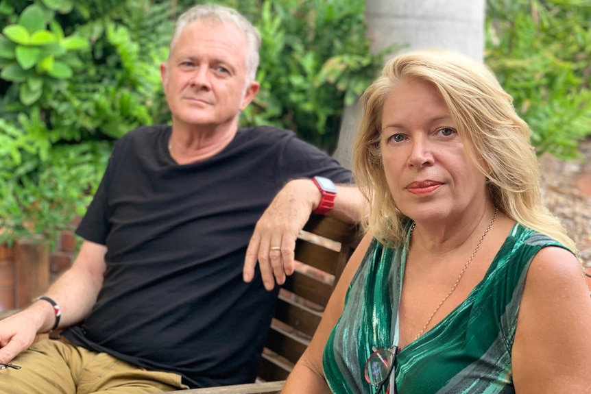 Image of a man and woman sitting next to each other on a bench in their back garden.