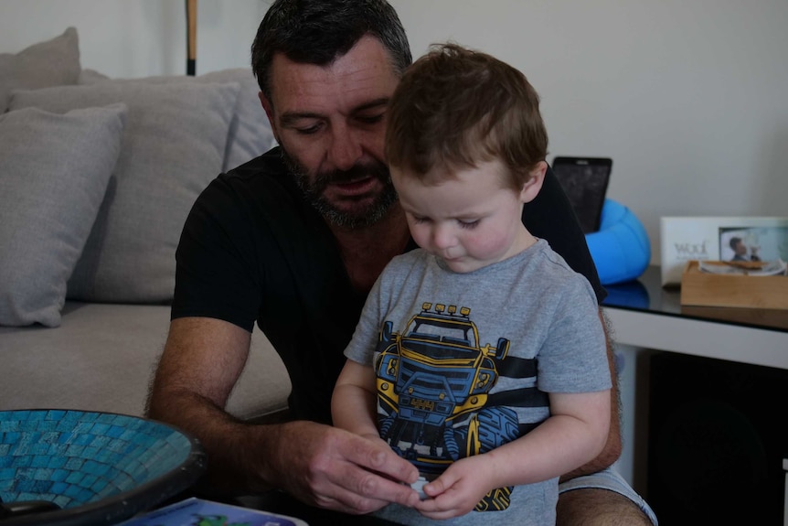 A father helps his young son with a jigsaw puzzle.