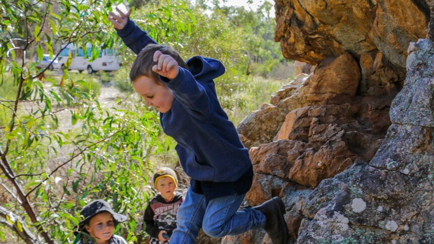One of the Natimuk kinder children jumps from a rock at Mt Arapiles