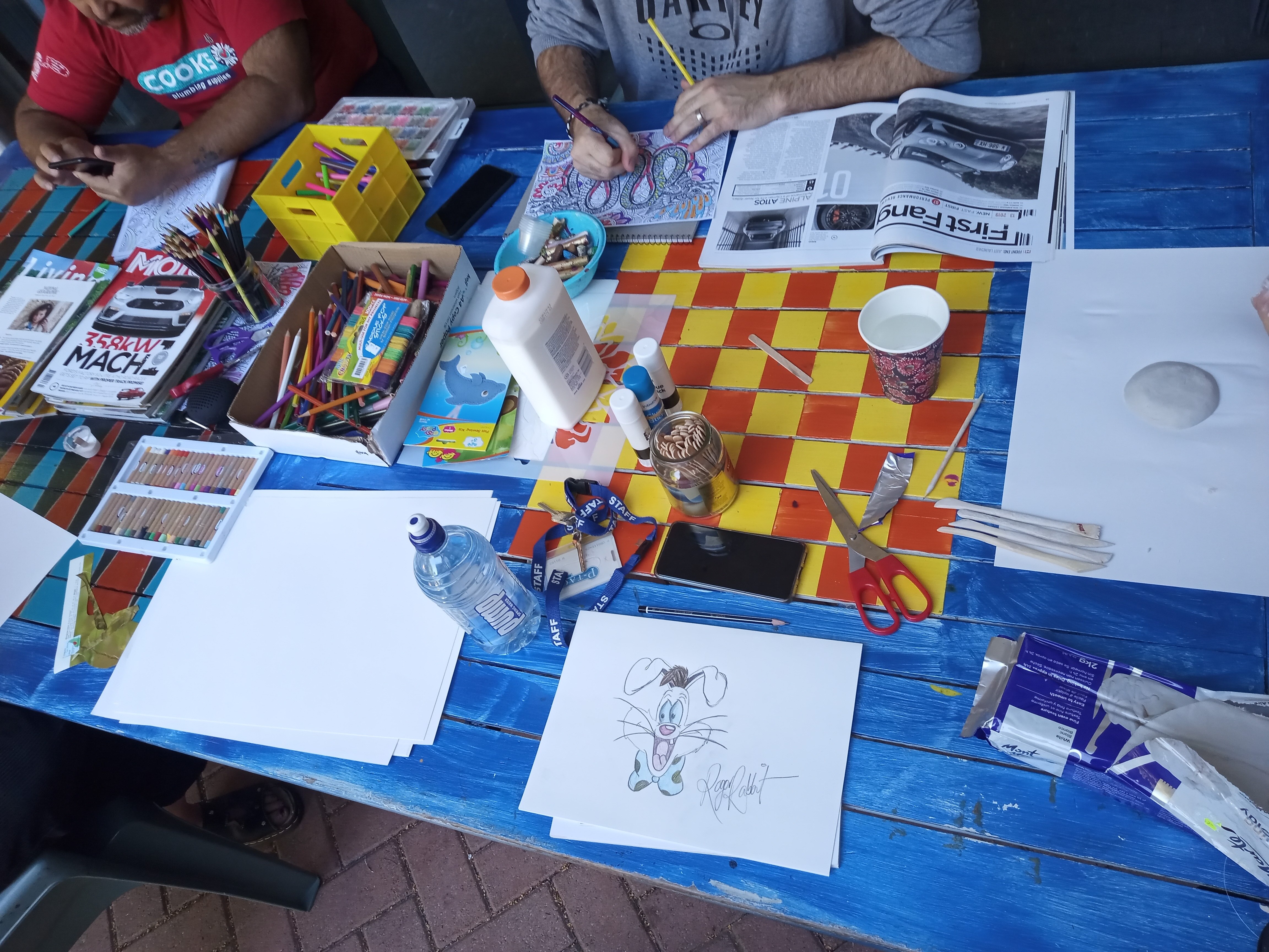 anonymous participants working on art projects at a desk