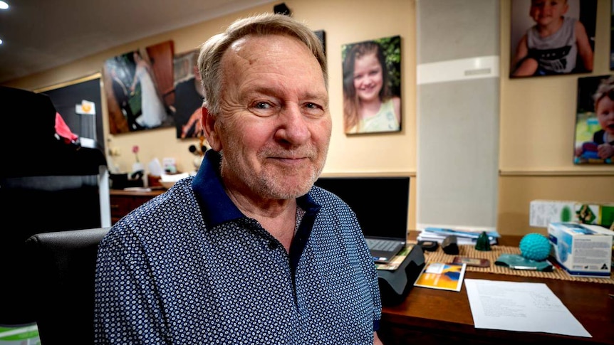 Adelaide man John Thorpe in a room with family photos.