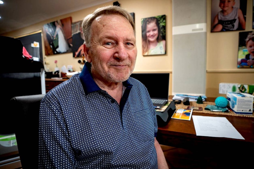 Adelaide man John Thorpe in a room with family photos.