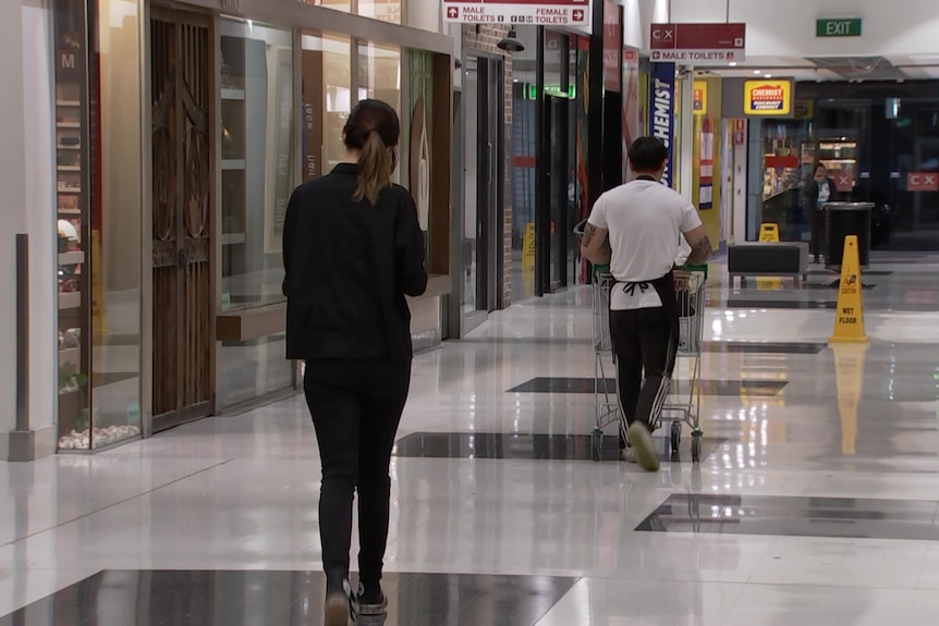 People walk through a shopping centre.